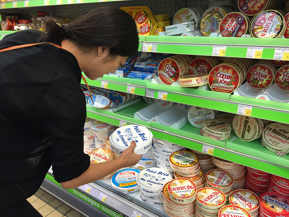 Japonaise au rayon fromage d'un supermarché français