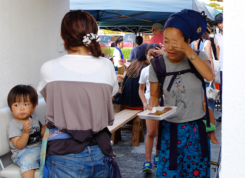 une mère de famille japonaise rasta, avec son bébé sur le dos