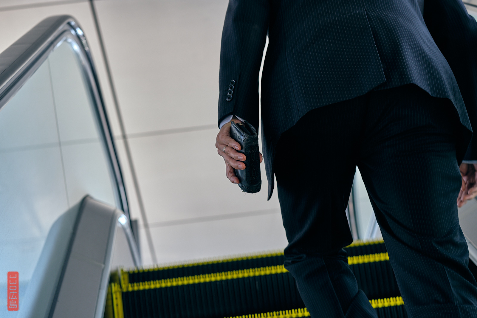 Salaryman dans un escalator, gare d'Hiroshima, Japon